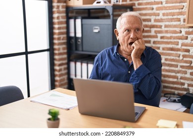 Senior Man With Grey Hair Working Using Computer Laptop At The Office Looking Stressed And Nervous With Hands On Mouth Biting Nails. Anxiety Problem. 