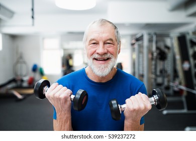 Senior Man In Gym Working Out With Weights.