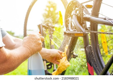 Senior Man Hand Cleaning The Bike By Spray And A Rag, Doing Maintenance Of His Bicycle, Sport Concept