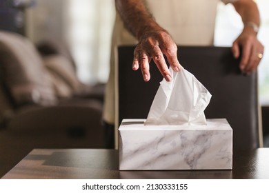 Senior Man Hand Picking Up Tissue Paper From Tissue Box On Dinner Table.