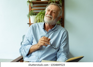 senior man happiness sitting and reading book at balcony near garden at nursing home for relaxing - Powered by Shutterstock