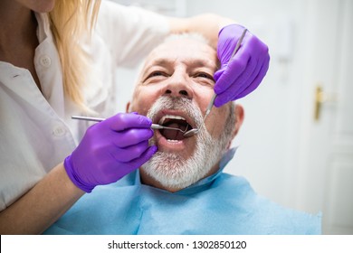 Senior Man Having Dental Treatment At Dentist's Office. 