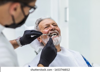 Senior Man Having Dental Treatment At Dentist's Office. 