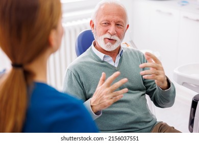 Senior Man Having Dentist Appointment Sitting At Dental Chair Consulting With Doctor At Dental Clinic