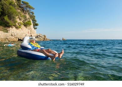 Senior Man With Hawaii Shirt And Flowers Floating At The Sea