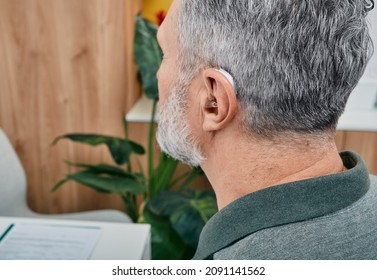 Senior Man With Hearing Aid Behind The Ear Can Hear Sounds. Hearing Loss Treatment Concept At Older People