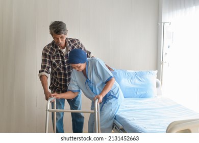 A Senior Man Helping Cancer Patient Woman Wearing Head Scarf With Walker At Hospital, Health Care And Medical Concept