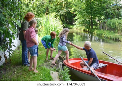 Senior man helping grandchild board rowing boat - Powered by Shutterstock