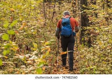 Senior Man Hiking In The Woods Carrying Backpack; Fall In Missouri, MIdwest