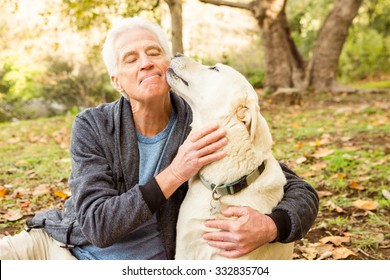 Senior Man With His Dog In Park On An Autumns Day