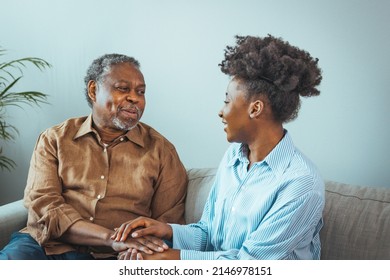 Senior man and his middle aged daughter smiling at each other embracing, close up. Portrait of a daughter holding her elderly father, sitting on a bed by a window in her father's room. - Powered by Shutterstock