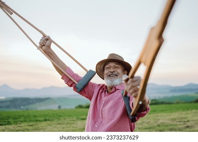 Senior man holding crutches in the air. Recovery, rehabilitation after injury or surgery in the nature. Concept of recovery and physical therapy - Powered by Shutterstock