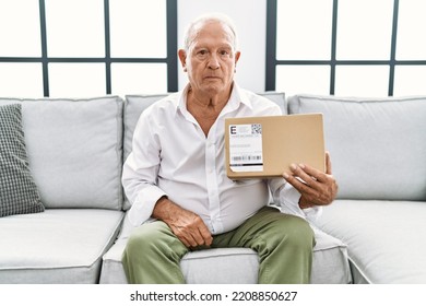 Senior Man Holding Delivery Package At Home Thinking Attitude And Sober Expression Looking Self Confident 