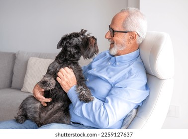 Senior man holding a dog in a retirement home - Powered by Shutterstock