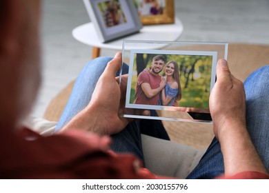 Senior Man Holding Frame With Photo Of Young Couple At Home, Closeup