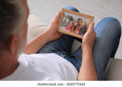 Senior Man Holding Frame With Photo Of Couple At Home, Closeup