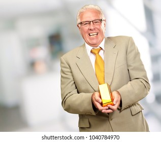 Senior Man Holding Gold Bar, Indoor