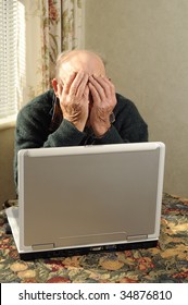 Senior Man Holding Head In Frustration While Looking At Computer