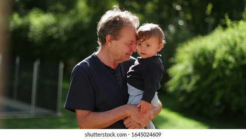 Senior Man Holding Infant Baby Outside. Grand Father Bonding With Toddler Outdoors