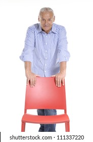 Senior Man Holding A Red Chair On White Background.