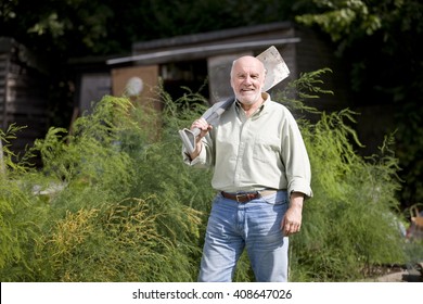 A senior man holding a spade on an allotment