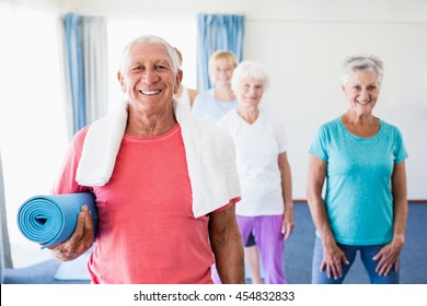 Senior Man Holding Yoga Mat During Sports Class