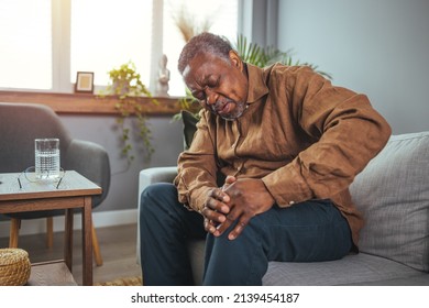 Senior man holds his hands up to his knees, knee pain, arthritis, arthrosis, meniscopathy, tendonitis. The concept of medicine, massage, physiotherapy, health. - Shutterstock ID 2139454187