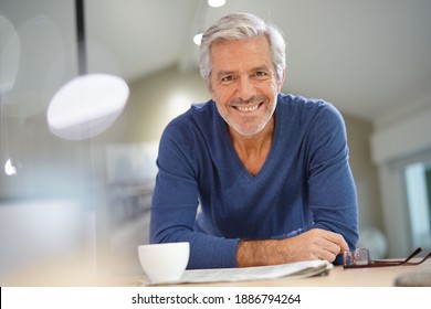 Senior man at home relaxing and reading newspaper - Powered by Shutterstock