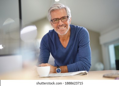 Senior man at home relaxing and reading newspaper - Powered by Shutterstock