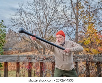 Senior Man (in Late 60s) Is Exercising With A Steel Mace In His Backyard, Fall Scenery