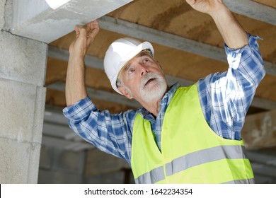 Senior Man Inspecting Lintel On Construction Site