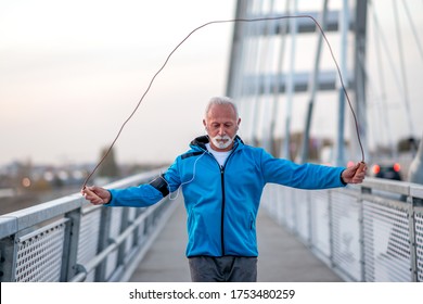 Senior man jogging outdoors at the bridge. Concept of healthy lifestyle. - Powered by Shutterstock