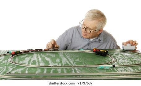 A Senior Man Just Setting Up His New N-Gauge Model Train.  Focus On Man's Eyes.  On A White Background.