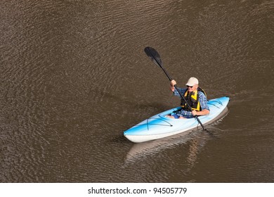 Senior Man Kayaking On Lake