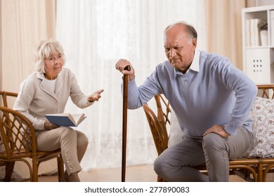 Senior man with knee arthritis and caring wife