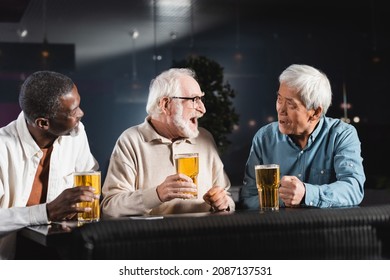 Senior Man Laughing While Drinking Beer With Multiethnic Friends