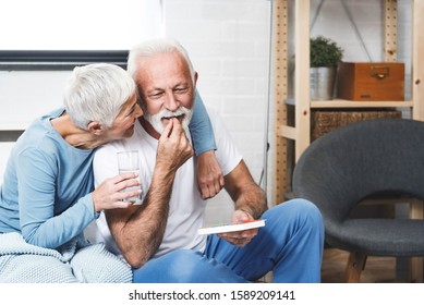 Senior man laughing while take medication for potency while his wife smile too. Elderly couple in bedroom. - Powered by Shutterstock