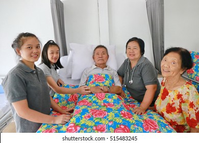 A Senior Man Laying On A Hospital Bed And Answering To His Doctor's Questions, Family Member Visit Around Bed, Asian Family Worry. 80s Man