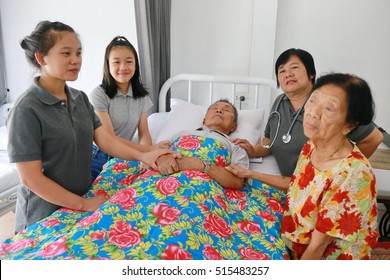 A Senior Man Laying On A Hospital Bed And Answering To His Doctor's Questions, Family Member Visit Around Bed, Asian Family Worry. 80s Man