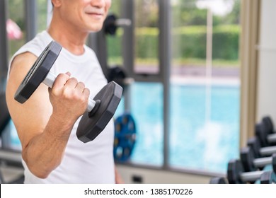 Senior man lifting dumbbell in fitness gym. Senior healthy lifestyle. - Shutterstock ID 1385170226