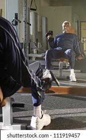 Senior Man Lifting Weights At A Gym
