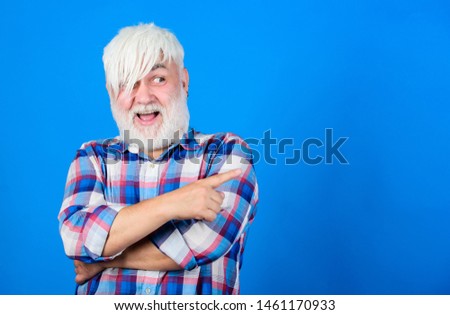Senior man with long bangs and beard. Mature hipster unusual appearance. Subculture and lifestyle. Barbershop and hairstylist. Expressing himself hairstyle. Subculture attributes. Emo subculture.