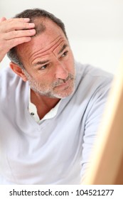 Senior Man Looking At His Hair In Mirror