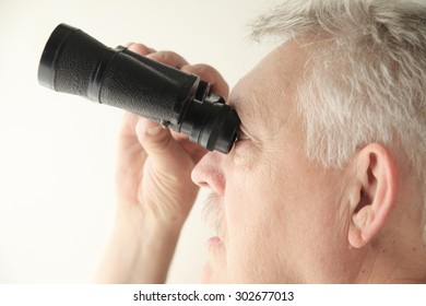 Senior Man Looking Upward With An Old Pair Of Binoculars, Copy Space Included.