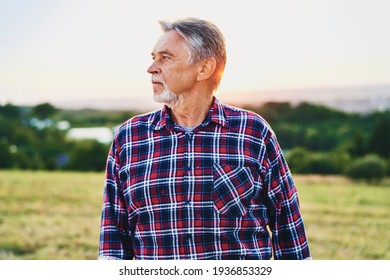 Senior Man blickt über sein Land bei Sonnenuntergang                               