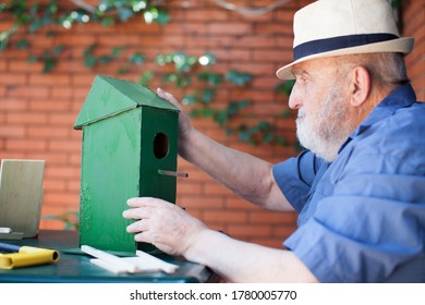 Senior Man Making A Birdhouse