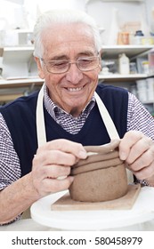 Senior Man Making Coil Pot In Pottery Studio