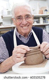 Senior Man Making Coil Pot In Pottery Studio