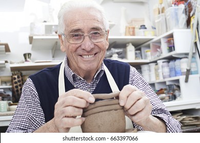 Senior Man Making Coil Pot In Pottery Studio