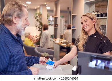 Senior Man Making Contactless Payment To Stylist In Salon With Credit Card - Powered by Shutterstock